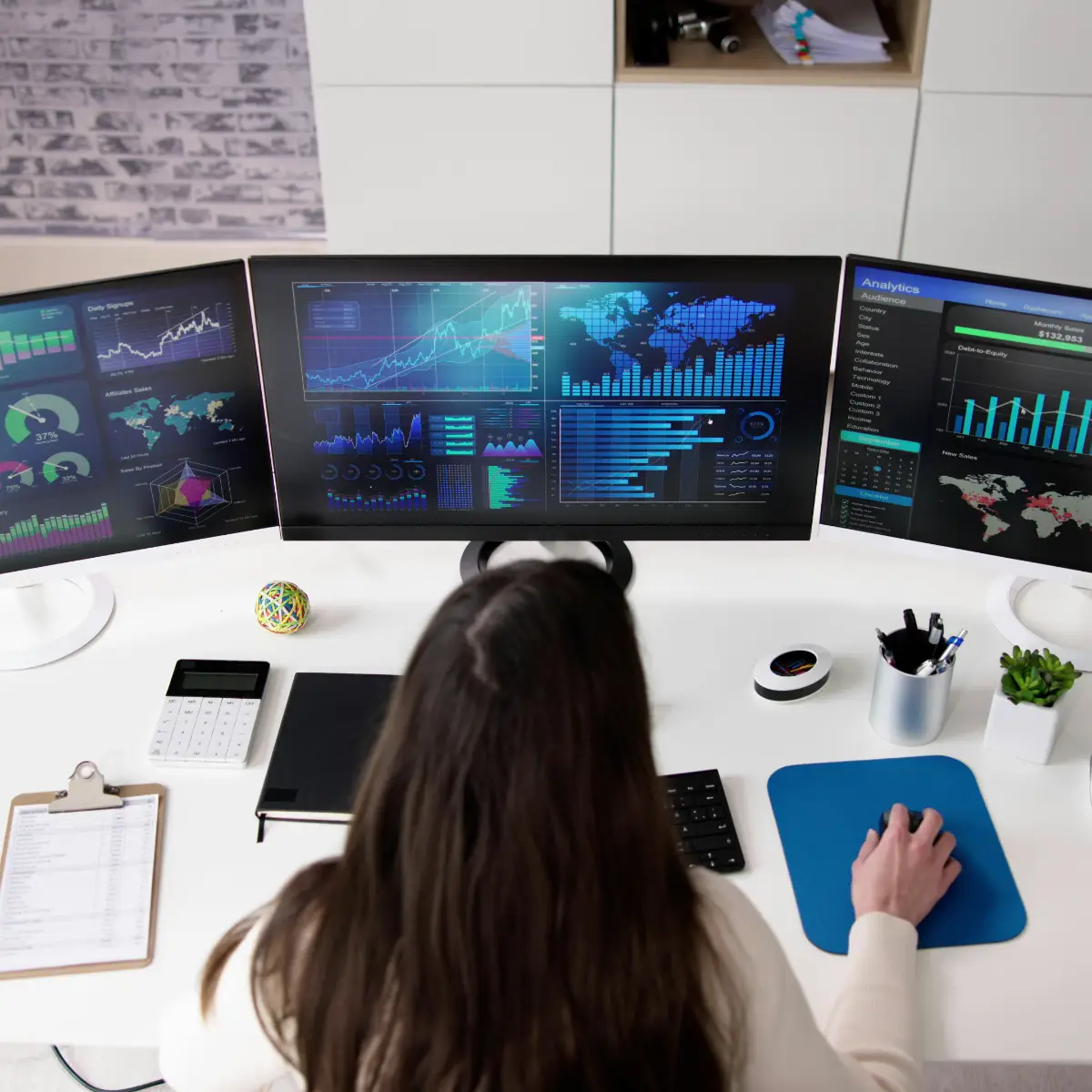 woman analyzing multiple screens of realtime financial data on her computer