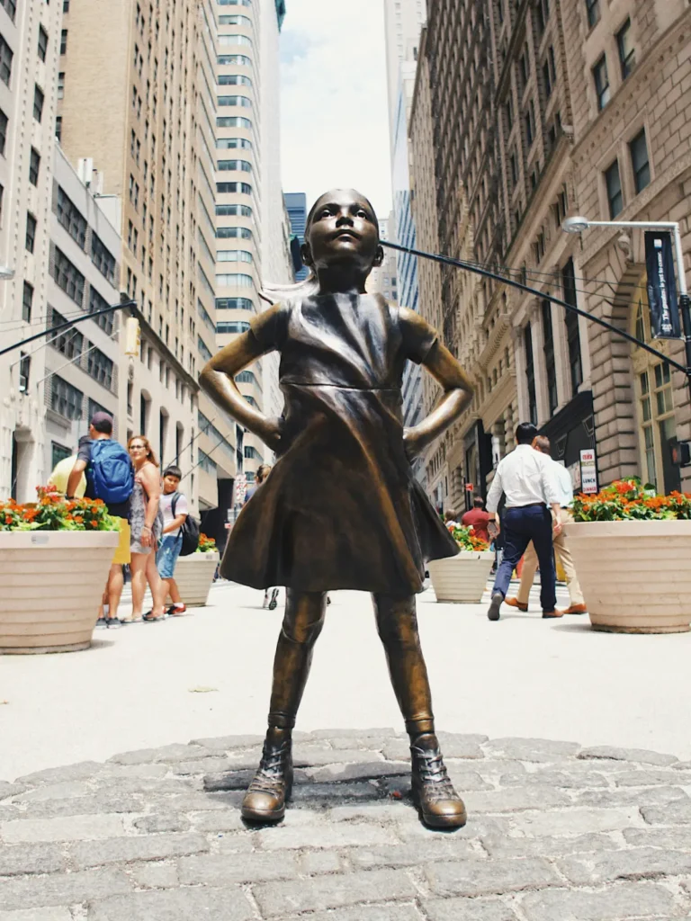 bronze wall street statue of girl confronting the bull