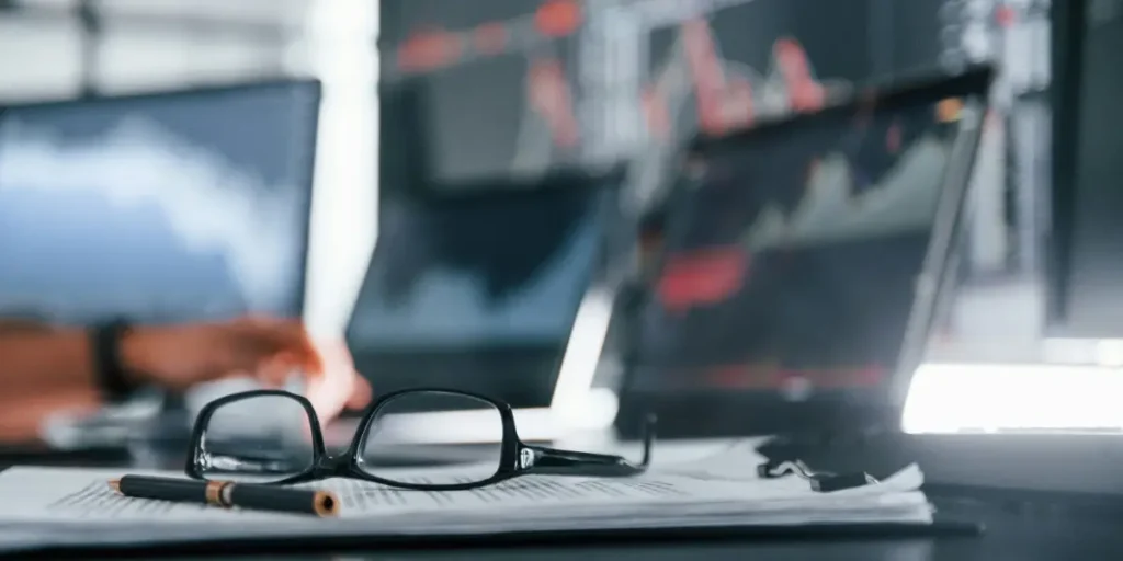 multiple computer monitors with realtime stock market data and price graphs